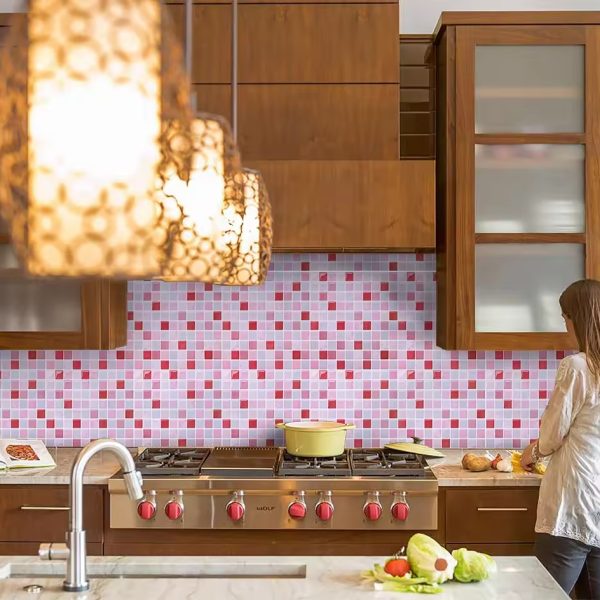 Pink Opulence tile backsplash installed on the wall of a large kitchen with wooden cabinets and grey stone countertop.